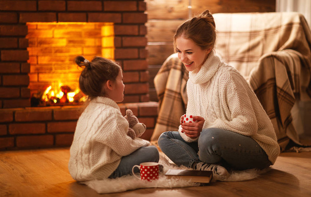 Rodzina matki i dziecka picia herbaty i śmiejąc się na zimowe nawet - Zdjęcie, obraz
