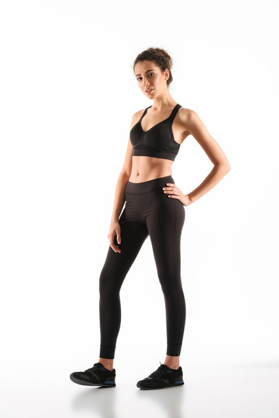 Full-length image of Smiling fitness woman holding arm on hip - Foto, immagini