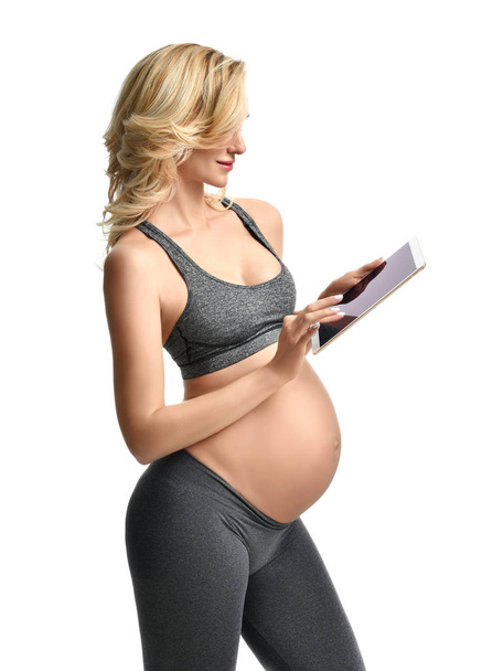 Beautiful pregnant woman with big belly use pregnancy motherhood expectation application typing on digital tablet pad  - Фото, изображение