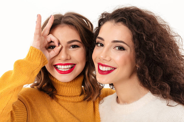 Close up image of two girls in sweaters having fun - Фото, зображення