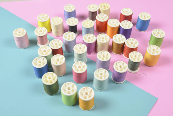 Flat lay of colored thread rolls for sewing on two tone backgrou - Foto, imagen