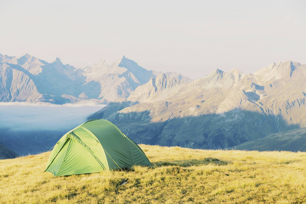 Tent standing on a mountain top. - Фото, изображение