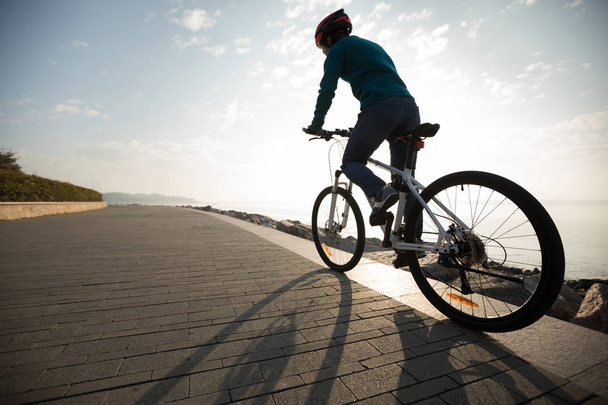 日の出の海岸のパスでサイクリスト乗馬自転車 - 写真・画像