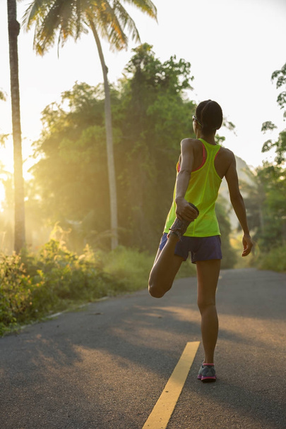 fitness mujer joven calentándose antes de correr por la mañana bosque tropical sendero
 - Foto, imagen