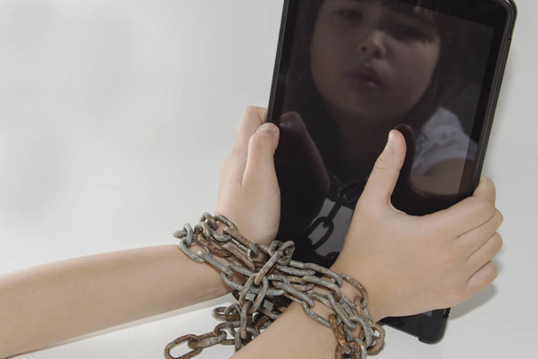 Iron chain ties together hands and smartphone - mobile phone addiction concept. - Photo, Image