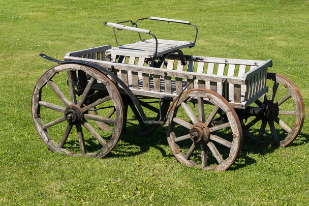 Vieux chariot en bois avec roues en bois dans le pré vert
  - Photo, image