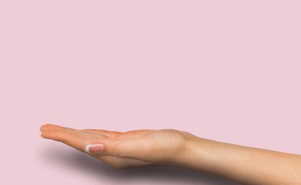 Wyciągniętą ręką kobiece na różowym tle - Zdjęcie, obraz