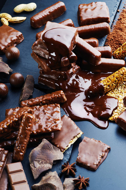 eine Vielzahl von Schokoladenprodukten auf dunklem Hintergrund. - Foto, Bild