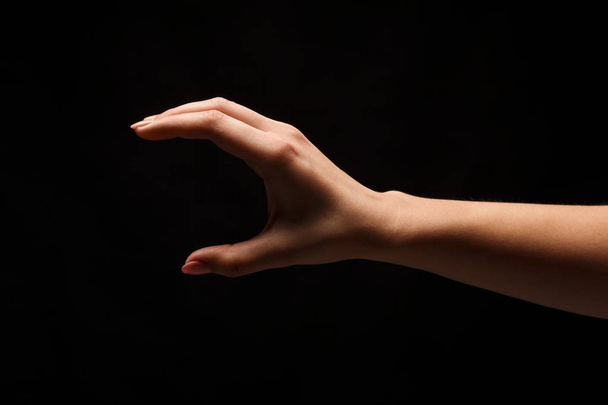 Vrouwelijke hand meten van iets, knipsel, gebaar - Foto, afbeelding