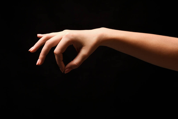 La mano femenina recogiendo algo, recorte en negro
 - Foto, Imagen