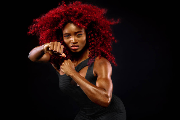 A strong athletic woman on black background wearing in sportswear, fitness and sport motivation. Sport concept with copy space. - Photo, Image