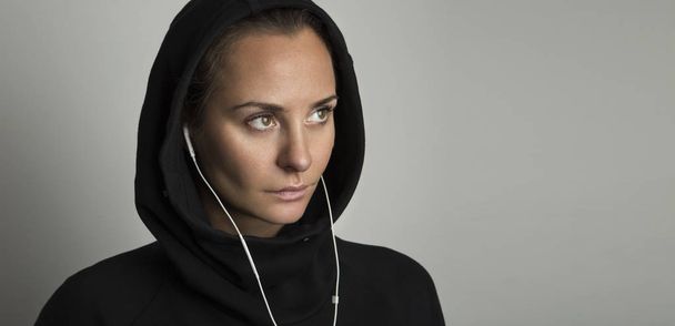 Portrait of young woman wears casual comfortable clothes, listens to relaxing music on earphones. - Foto, afbeelding