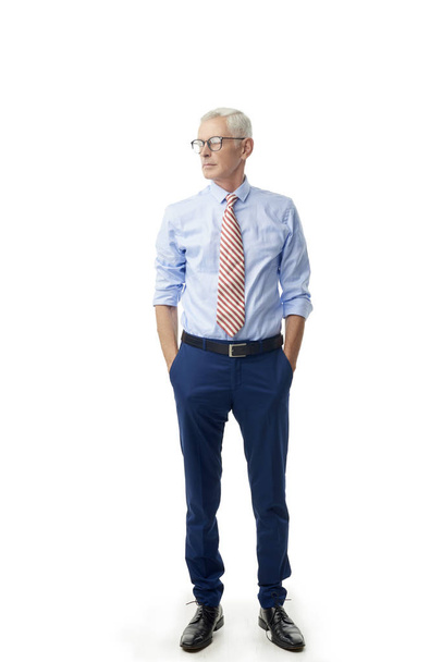 Full length shot of senior businessman standing with rolled up sleeves shirt and tie at isolated white background.  - Foto, Imagem