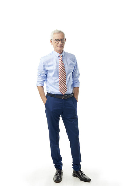Full length shot of senior businessman standing with rolled up sleeves shirt and tie at isolated white background.  - 写真・画像