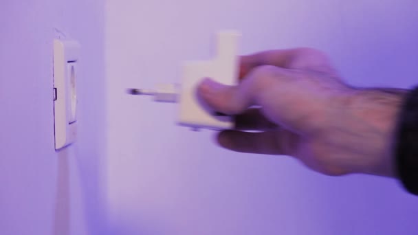Hombre insertar repetidor WiFi en el enchufe eléctrico en la pared. El dispositivo ayuda a extender la red inalámbrica en el hogar u oficina
. - Imágenes, Vídeo