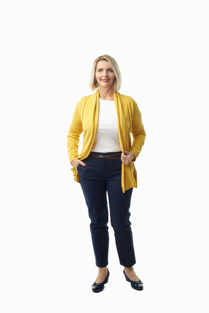 Full length shot of a beautiful senior woman wearing casual clothes while standing at isolated white background. - Foto, imagen