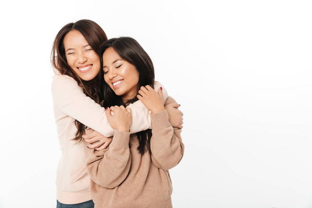 Two asian cute ladies sisters standing isolated - Fotografie, Obrázek