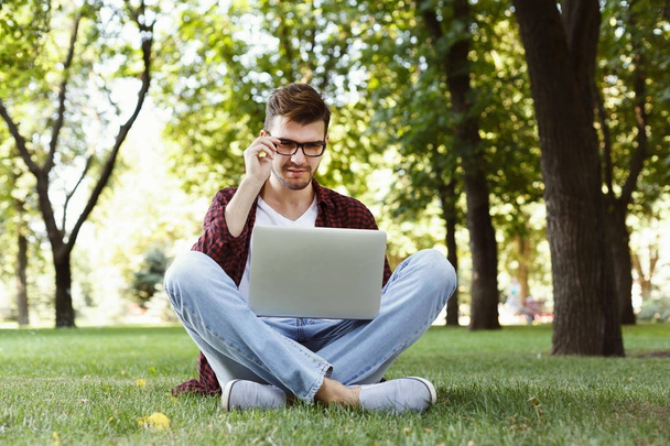 Beau jeune homme utilisant un ordinateur portable à l'extérieur
 - Photo, image
