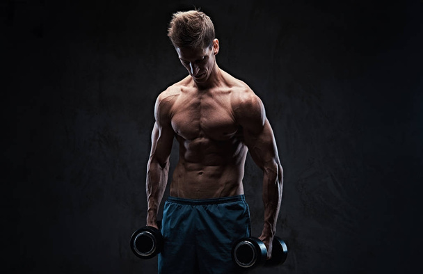 Sportovní košili mužské biceps činka cvičení nad tmavě šedé zázemí. - Fotografie, Obrázek