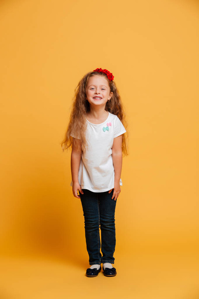 Little girl child standing isolated over yellow - Фото, изображение