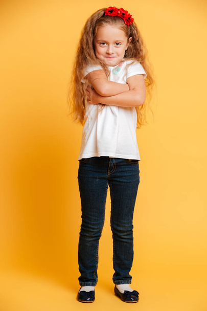 Funny girl child standing isolated with arms crossed - Фото, изображение