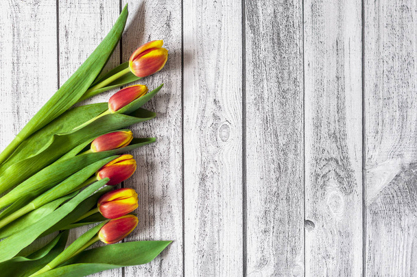 Buquê de tulipas coloridas em uma mesa de madeira
 - Foto, Imagem