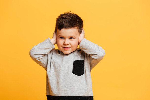 Little boy child standing isolated covering ears with hands. - Fotoğraf, Görsel