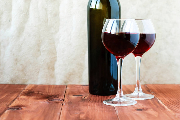 δύο ποτήρια κόκκινο κρασί σε ξύλινο τραπέζι - Φωτογραφία, εικόνα