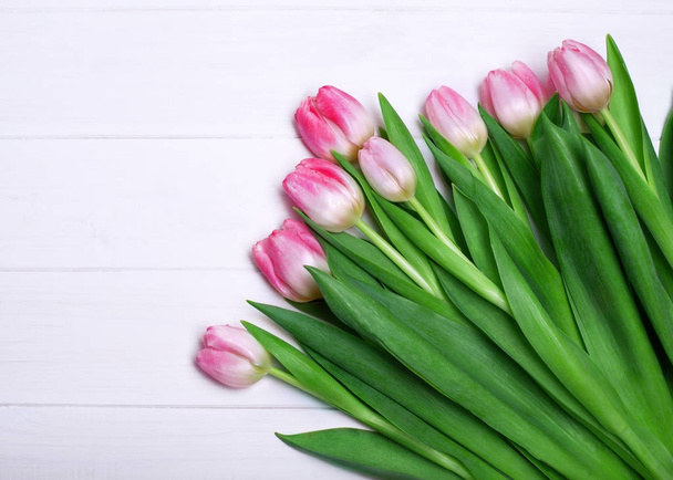 Zarte Komposition aus rosa Tulpen auf weißem Holzgrund. Konzept zum Frauentag - Foto, Bild