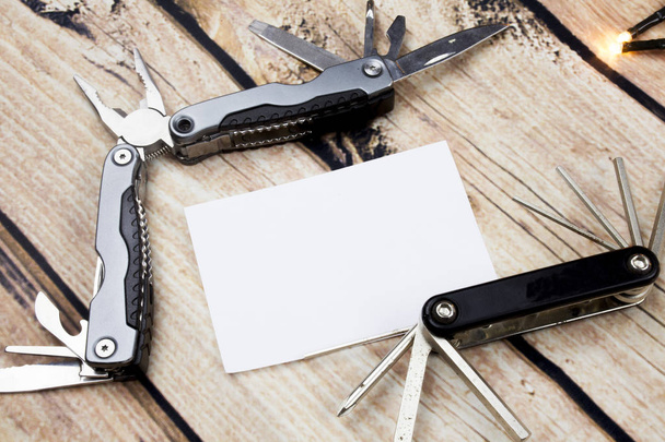 Adesivi carta bianca su tavolo di legno. Nota adesiva vuota con coltello da tasca luci
 - Foto, immagini