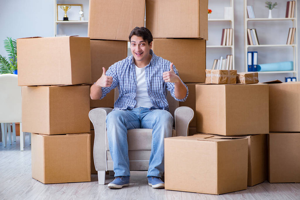 Jeune homme emménageant dans une nouvelle maison avec des boîtes - Photo, image