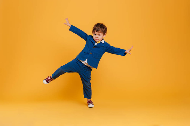 Funny little boy child standing isolated over yellow - Fotografie, Obrázek