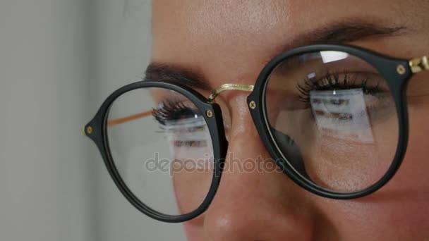 Reflection at the glasses of young woman: looking a site - Footage, Video