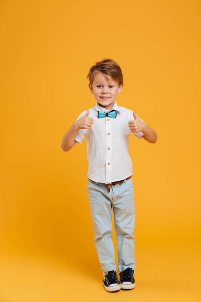 Little boy child standing isolated showing thumbs up. - 写真・画像