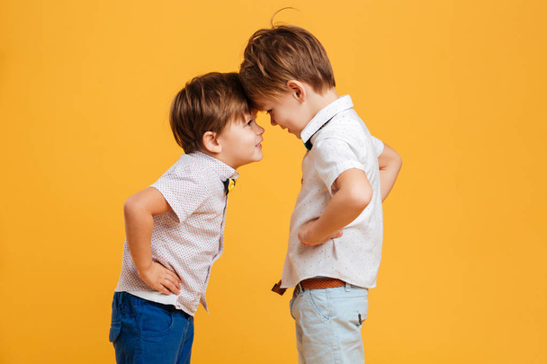 Funny little children brothers isolated over yellow - Photo, image