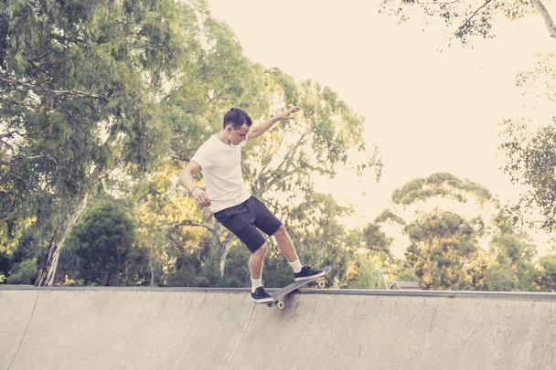 man beoefenen radicale skate board springen en genieten van trucs en stunts in concrete Halve pijp schaatsen bijhouden in sport en een gezonde levensstijl  - Foto, afbeelding