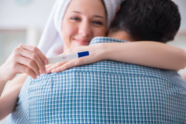Vrouw en echtgenoot kijken naar zwangerschapstest - Foto, afbeelding