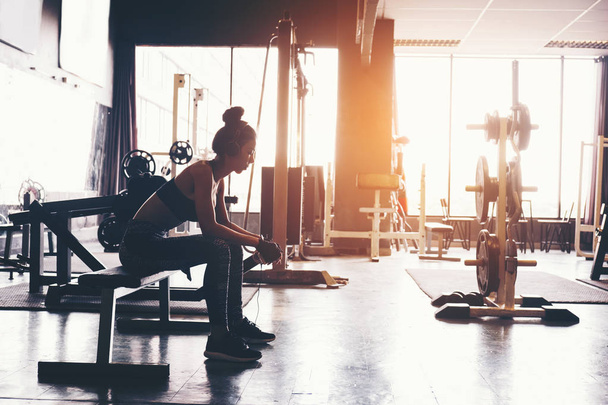 Fitness girl using smartphone and Headphones in fitness gym - Fotografie, Obrázek