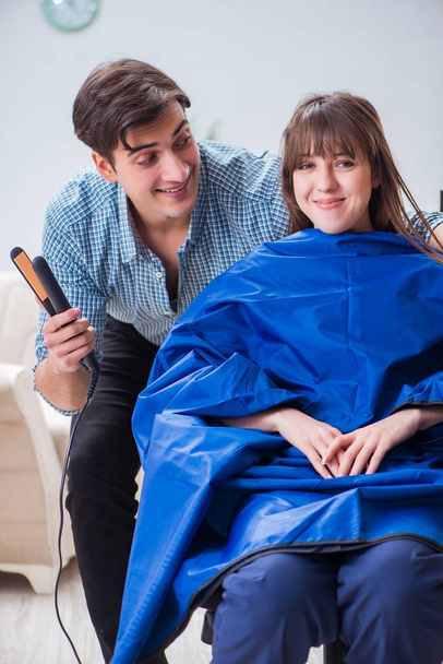 Man male hairdresser doing haircut for woman - Foto, afbeelding