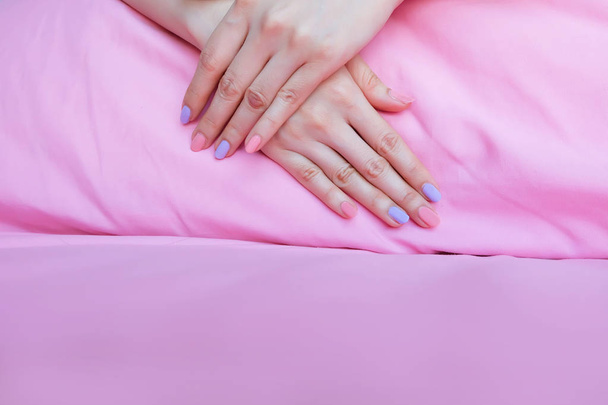 Beautiful Pink Nail Polish. Female Hands with Pink Nails Manicure on Pink Fabric Background Great for Any Use. - Foto, imagen