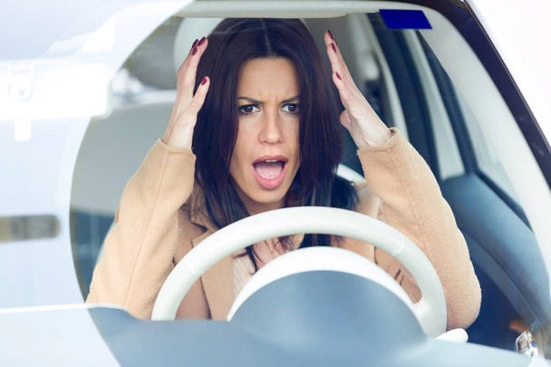 Jeune femme d'affaires nerveuse conduisant sa voiture
. - Photo, image