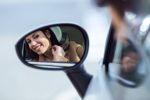 Beautiful young woman looking in the rearview mirror. - Fotó, kép