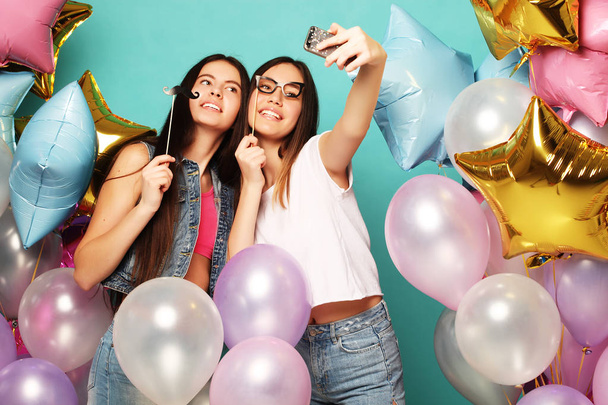 Two   girls friends with colorfoul  balloons make selfie on a ph - Fotografie, Obrázek