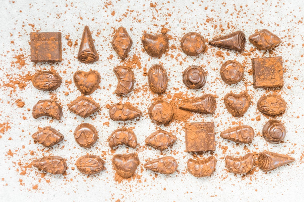 Şekerli tatlı koyu çikolata parçaları ve beyaz taş zemin üzerine kakao tozu - Fotoğraf, Görsel