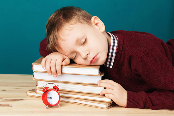 tired school boy asleep on books. little student sleeping on tex - 写真・画像