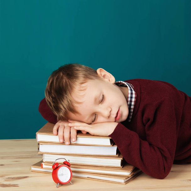tired school boy asleep on books. little student sleeping on tex - Фото, изображение