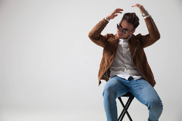 seated fashion man fixes his hairstyle  - Photo, Image