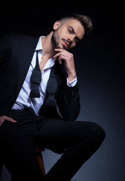 arrogant elegant man in tuxedo holding hand on chin  - Fotografie, Obrázek