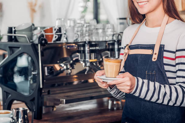 asia woman barista wear jean apron holding hot coffee cup served - 写真・画像