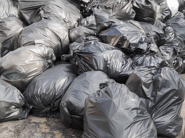 Pile of black garbage bags with trash on the floor. - Photo, Image